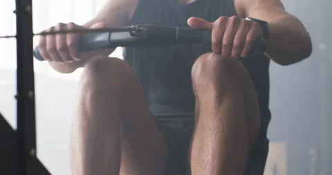 Using rowing machine, man exercising in gym, focusing on fitness and strength Stock Footage 299232913