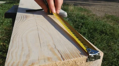 Using a ruler, the worker marks the dimensions with a pencil. Yellow tape Stock Footage 167196583