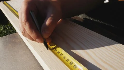 Using a ruler, the worker marks the dimensions with a pencil. Yellow tape Stock Footage 169315344