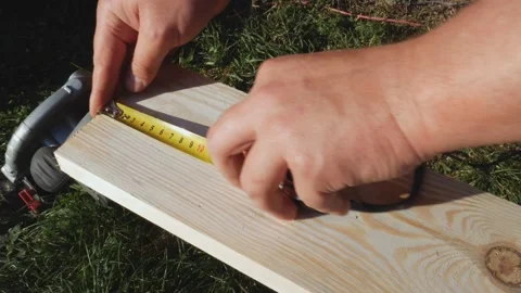 Using a ruler, the worker marks the dimensions with a pencil. Yellow tape Stock Footage 169848594