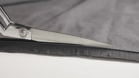 Using scissors to cut black cloth Stock Footage 344927760