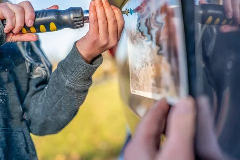Using a screw driver to remove and replace a vehicle rear license plate. Foto stock