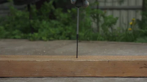 Using a screwdriver, hand screw the screw into the board. Stock Footage 131259201