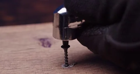Using a screwdriver to insert a screw securely into a piece of wood during Stock Footage 297953039