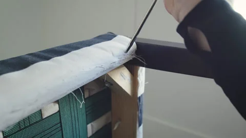 Using a screwdriver to remove staples from chair upholstery Stock Footage 310303361