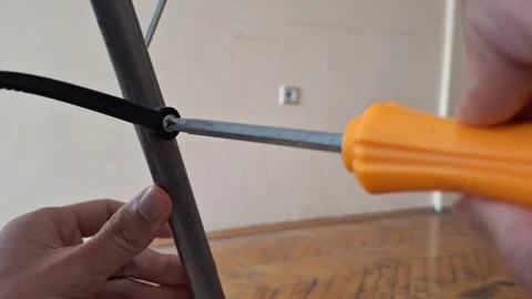 Using Screwdriver to Tighten Metal Frame Stock Footage 331457332