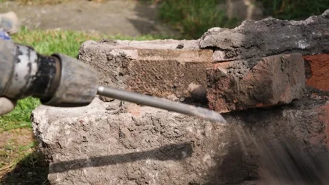 Using SDS drill to break bricks out of concrete block Video stock 275298473