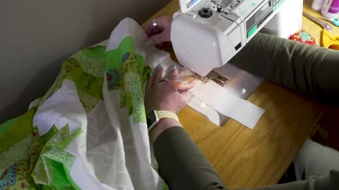 Using a sewing machine to attach the border around the edge of the joined Stock Footage 171453480