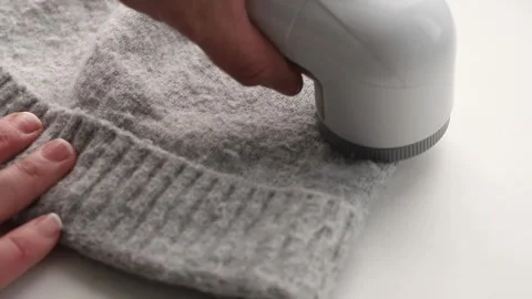 Using sheaving lint balls from winter hat with lint shaver. Video stock 262734190