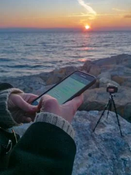 Using Smart Phone and Camera on Seaside in Focus Stock Photos