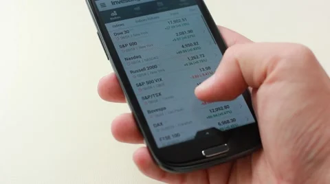 Using smart phone to check internet stock market exchange trading graph Stock Footage 56909963