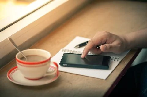 Using smart phone with coffee cup Stock Photos