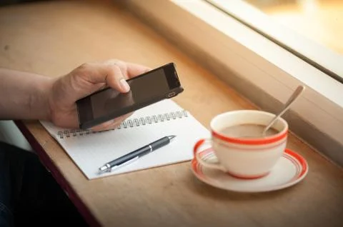 Using smart phone with coffee cup Stock Photos