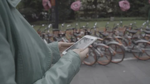 Using smart phone, mobikes in background, Shanghai China Stock Footage 113894459