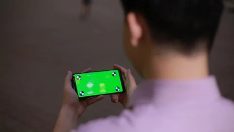Using smart phone on in the Park by Asian boy close up-green screen Stock Footage 93256245
