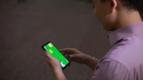 Using smart phone on in the Park by Asian boy close up-green screen Stock Footage 93256876