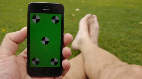 Using a smart phone at the park. Chroma Key Stock Footage 33341961