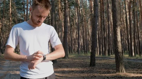 Using smart watch at jogging exercise in the forest Video stock 111699482