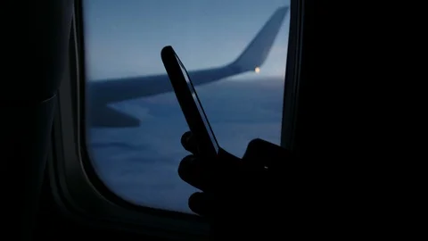Using smartphone and dials a message on the phone on the airplane against the Stock Footage 95681818