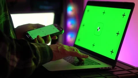 Using smartphone and laptop with green screen setup Stock Footage 317856460