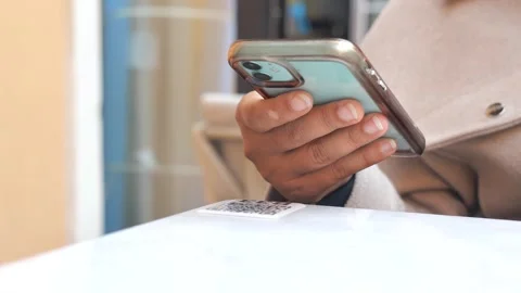 Using a smartphone at a cafe to scan a QR code Stock Footage 321264980
