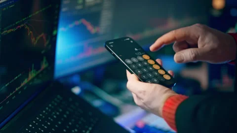Using Smartphone Calculator App Financial Trading Charts Laptop Screen Stock Footage 338353949