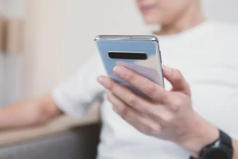 Using a smartphone for everyday purposes at home. Close-up on the phone in woman Stock Photos