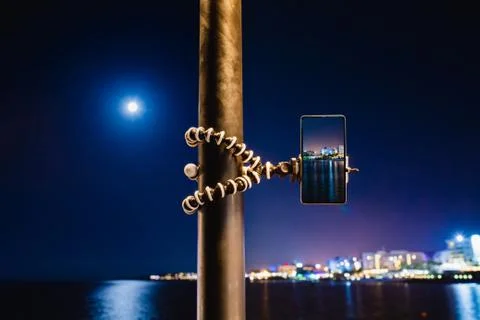 Using smartphone on flexible tripod to making the photo of sea night landscape Stock Photos