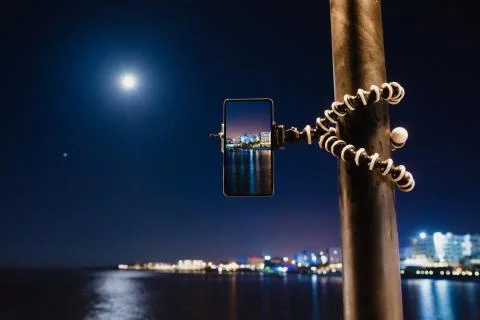 Using smartphone on flexible tripod to making the photo of sea night landscape Stock Photos