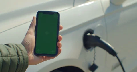 Using smartphone with green screen and waiting power supply connect to electric Stock Footage 128643780