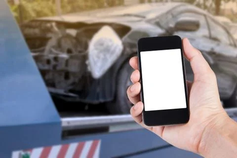 Using smartphone on hand with blurry background of black car on accident on t Stock Photos