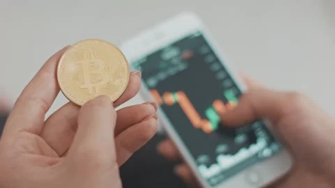 Using a smartphone with a hand. Stock market online. Bitcoin is a worldwide Vidéo 87930461