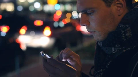 Using smartphone in night city outside, mobile internet app for taxi or email Stock Footage 106212359