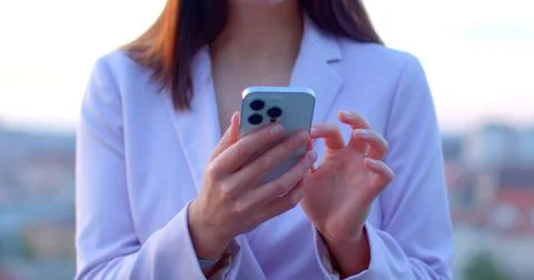 Using smartphone in urban setting at sunset. Close-up of phone in hand. AI chat Stock Photos