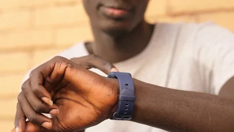 Using the smartwatch - black man's hands typing on smartwatch in the street Stock Footage 217781336