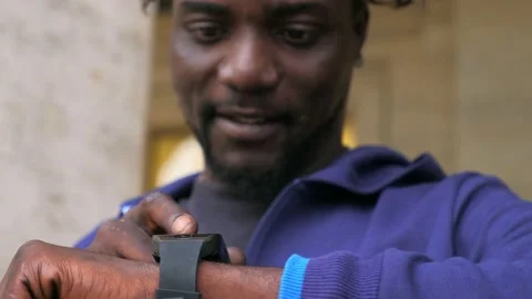 Using the smartwatch - black man's hands typing on smartwatch in the street 스톡 동영상 218618838