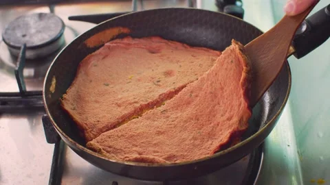 Using a spatula, lift the red omelette from the pan Vídeo Stock 312720354
