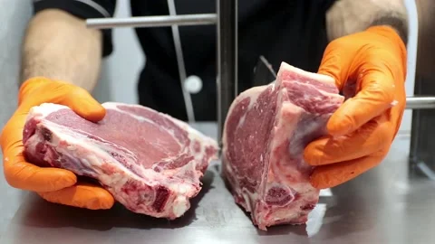 Using special equipment, the cook cuts the meat into delicious steaks Stock Footage 201325232