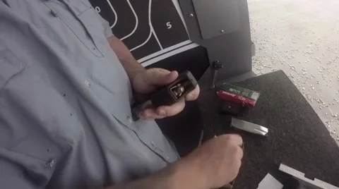 Using speed loader to load ammo into magazine Stock Footage 61094219