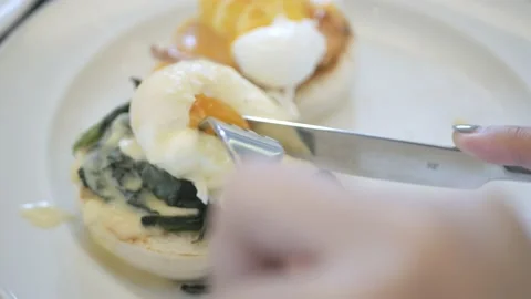 Using spoon and fork cutting the Florentine egg. Healthy Breakfast meal Stock-Footage 199009416