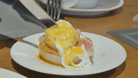Using spoon and fork cutting the egg benedict. Healthy Breakfast meal Stock Footage 220732604