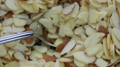 Using a spoon in sliced almonds Stock Footage 63919058