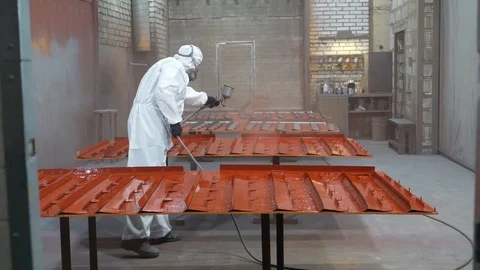 Using spray gun, applies coating composition to metal workpieces, spraying Stock Footage 120064428