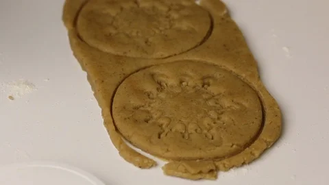 Using a stamp, a woman applies a pattern to gingerbread cookie blanks. Close- Stock Footage 121179415