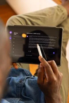 Using stylus on AI chatbot on tablet, man reading about implementing CRM system Stock Photos