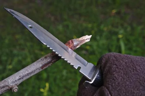 Using a survival knife to make an arrow Foto stock