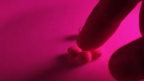 Using a syringe and pills in the red neon light of a nightclub Stock Footage 170599804