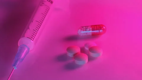Using a syringe and pills in the red neon light of a nightclub Stock Footage 170599903