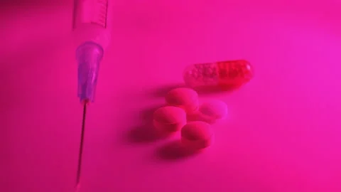 Using a syringe and pills in the red neon light of a nightclub Stock Footage 170599937