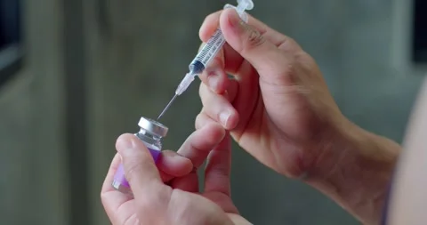 Using syringe prick into the medicine bottle. Stock Footage 254198183